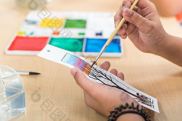 艺术绘画类学校年轻的学生的手刷着色水彩油漆工艺画纸