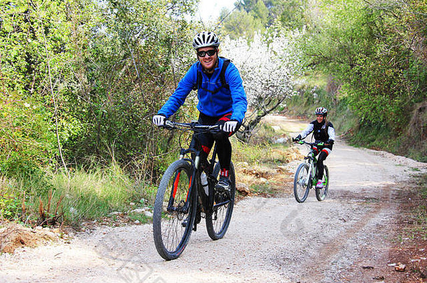 年轻的夫妇骑自行车森林小道
