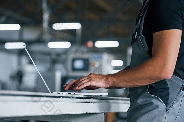 现代移动PC打字键盘工业工人在室内工厂年轻的技术员橙色硬他