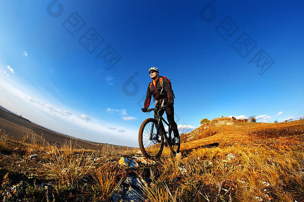 山自行车骑自行车的人骑单跟踪户外蓝色的天空背景