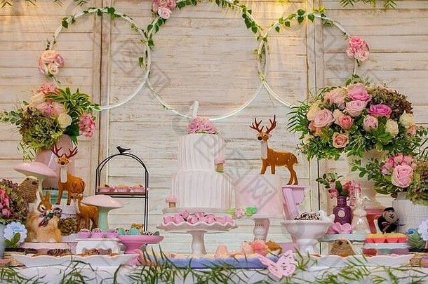 豪华的表格糖果生日蛋糕装饰花安排精致的野生动物光木面板背景情郎