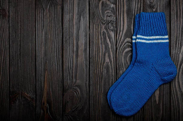 针织蓝色的羊毛袜子黑暗木背景