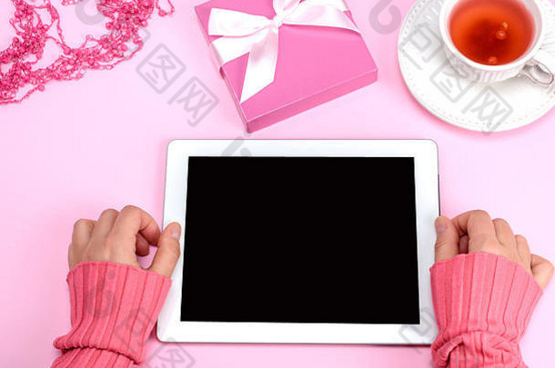 女手粉红色的毛衣持有电子平板电脑空黑色的屏幕粉红色的表面前视图