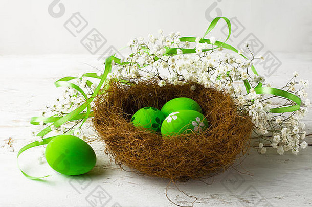 绿色复活节鸡蛋巢绿色缎丝带白色木背景