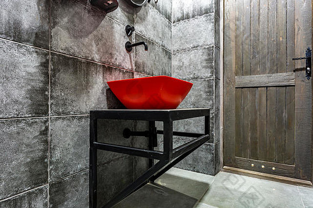 红色的脸盆水龙头昂贵的阁楼浴室精英体育运动酒吧黑色的砖墙背景