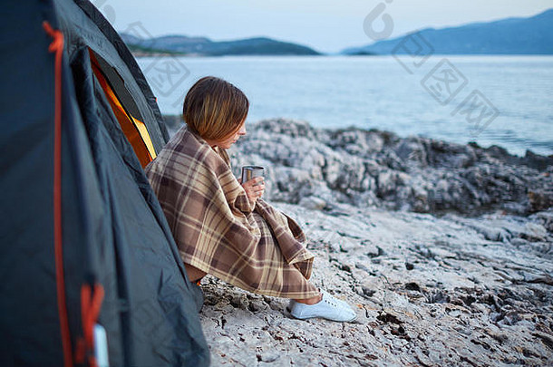 一边视图女孩坐着帐篷持有杯香茶