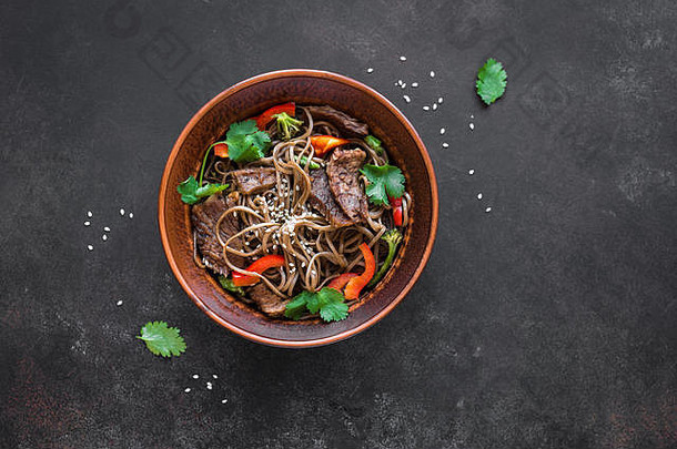 搅拌弗莱荞麦面条牛肉蔬菜亚洲健康的食物搅拌炸餐碗黑色的背景复制空间