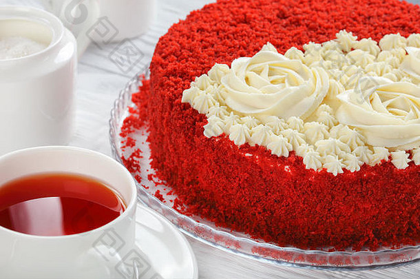 特写镜头美味的自制的红色的天鹅绒蛋糕超过美丽的奶油玫瑰撒红色的海绵蛋糕面包屑玻璃菜杯