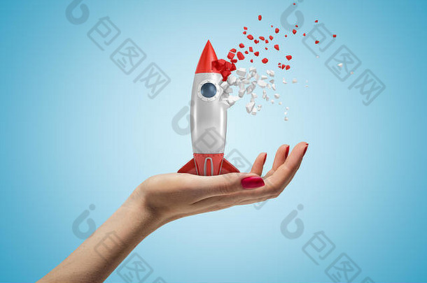 一边特写镜头视图女人的手面对持有玩具火箭开始disslove块光蓝色的背景