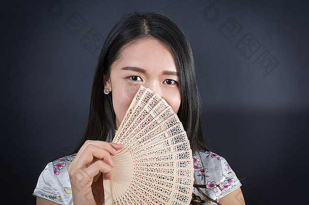 美丽的亚洲女人持有手风扇