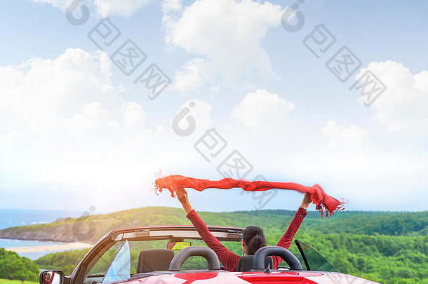 女孩红色的可转换车背景海景披肩挥舞着风