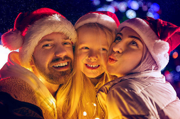家庭圣诞节假期季节人概念快乐家庭灯城市背景雪晚上