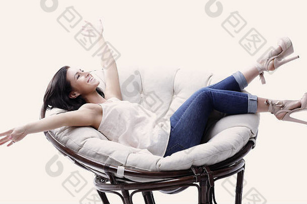 现代年轻的女人放松轮舒适的软椅子