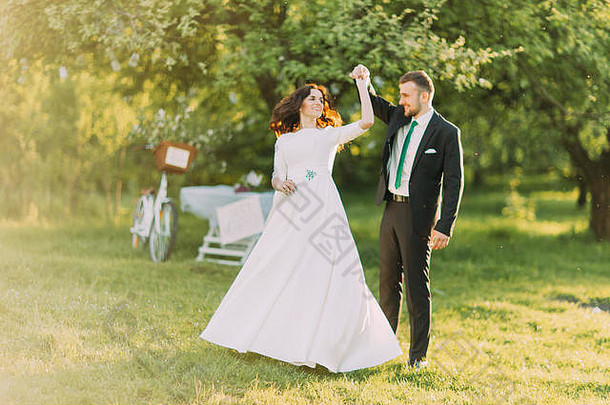 快乐结婚了夫妇跳舞草坪上绿色阳光明媚的公园