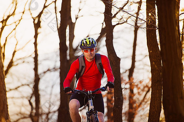 骑自行车的人男人。骑山自行车户外小道秋天森林