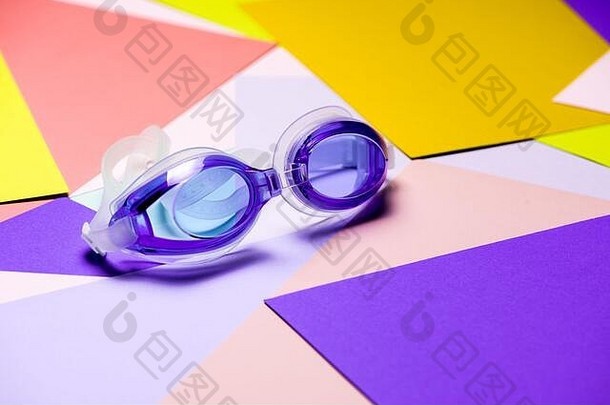 蓝色的游泳眼镜橡胶带多色几何背景产品概念