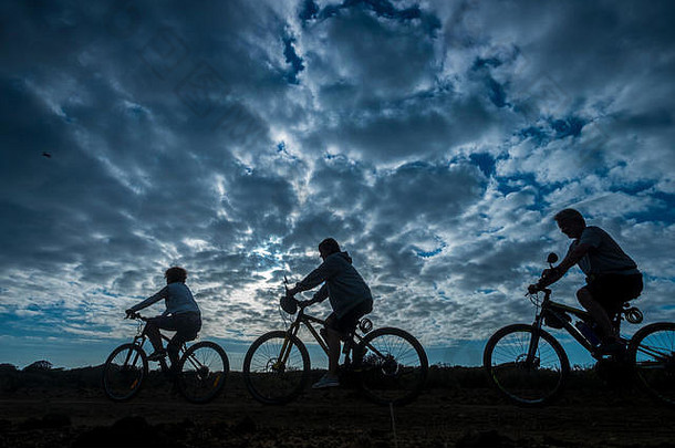 集团人骑山自行车美丽的黑暗多云的日落户外自然体育运动活动希希蒂生活方式自行车