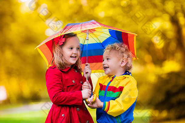 女孩玩多雨的夏天公园孩子彩虹伞防水外套靴子跳水坑雨