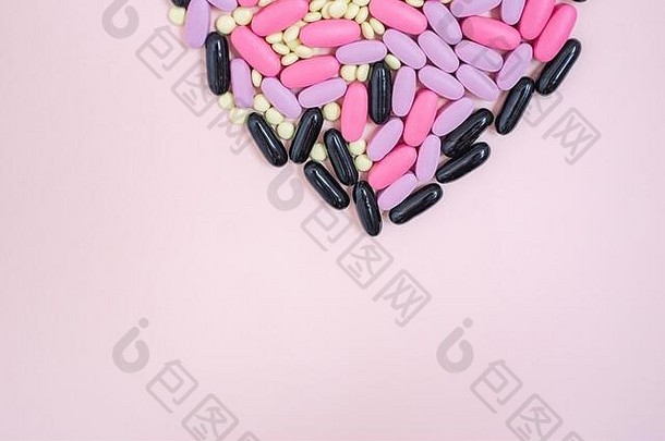 分散色彩斑斓的药品心形状的药片粉红色的背景抗生素抗菌药片胶囊有创意的的想法医学药物