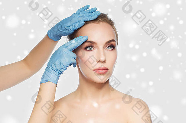 外科医生美容师手触碰女人脸