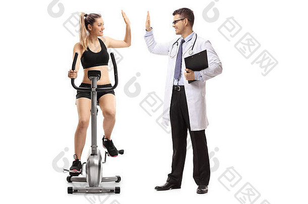 年轻的女人锻炼静止的自行车五次医生孤立的白色背景