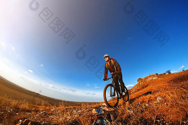 山自行车骑自行车的人骑单跟踪户外蓝色的天空背景