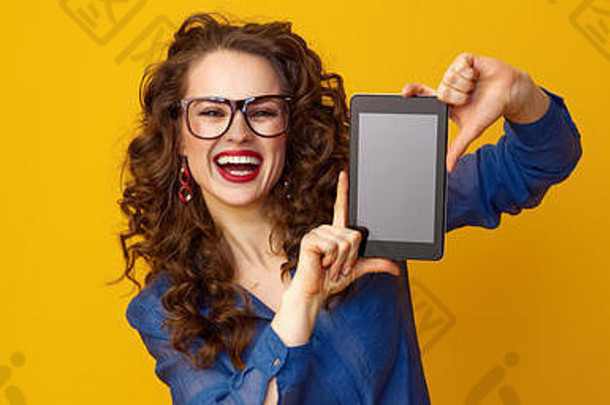 快乐年轻的女人长波浪浅黑肤色的女人头发显示平板电脑空白屏幕黄色的背景