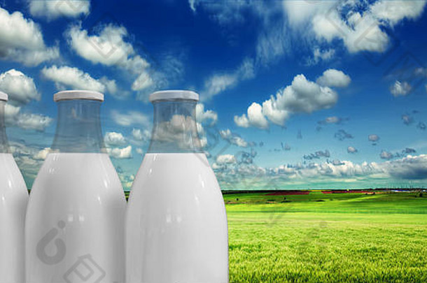 在夏日草地和天空的背景下，瓶装牛奶