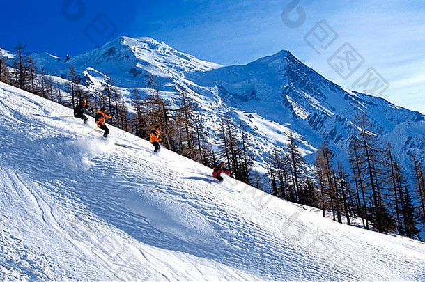 法国阿尔卑斯山夏蒙尼地区，一组四名滑雪者在粉雪中嬉戏