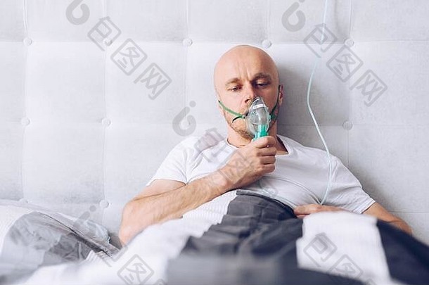 男人。呼吸氧气面具床上科维德病人