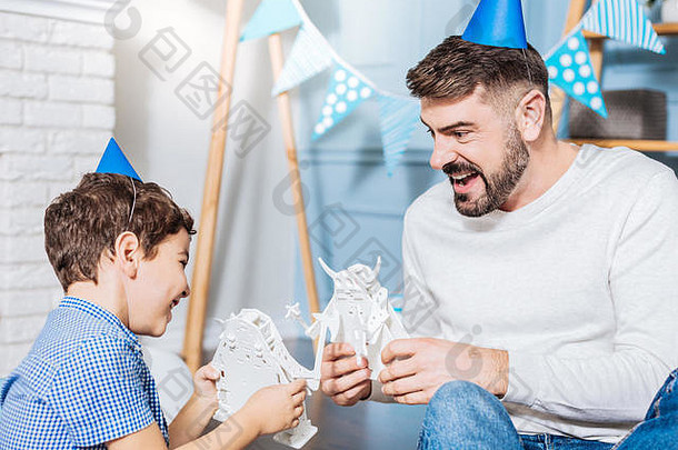 快乐的父亲和儿子享受玩具机器人的战斗