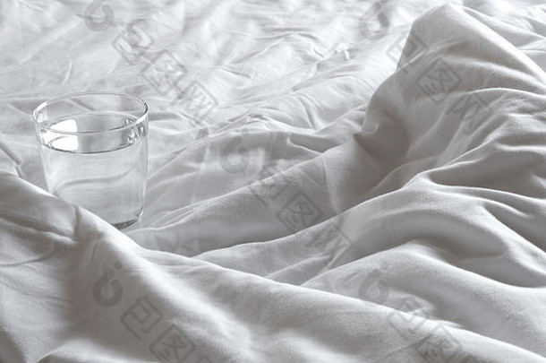 玻璃水毯子皱巴巴的床上