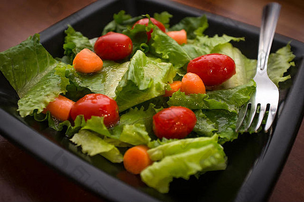 新鲜的有机花园沙拉配意大利调味品，放在方形黑盘子上
