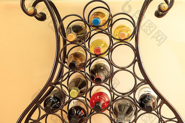 酒架上摆放着各种红葡萄酒和白葡萄酒，呈杆状铁圈排列。