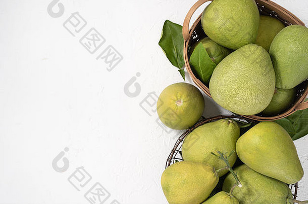 新鲜柚子、柚子、葡萄柚、柚子，白色水泥背景，竹篮中。秋季时令水果，俯视，平放，桌面拍摄。