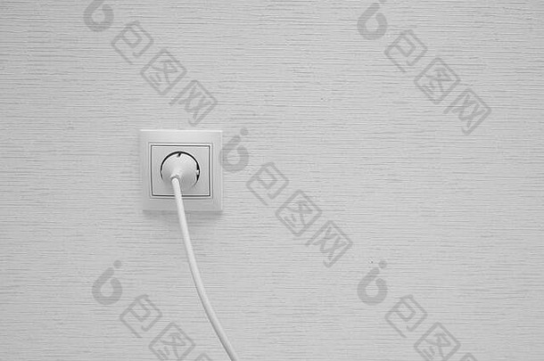 墙上电源插座上的白色电气插头。