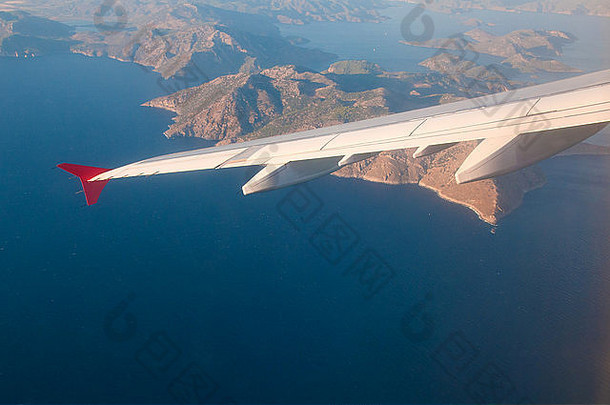 从飞机上俯瞰大海、群山和机翼