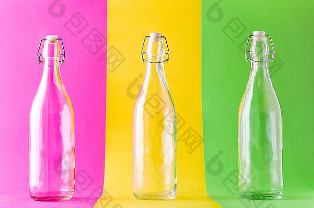 三个彩色背景的空玻璃瓶