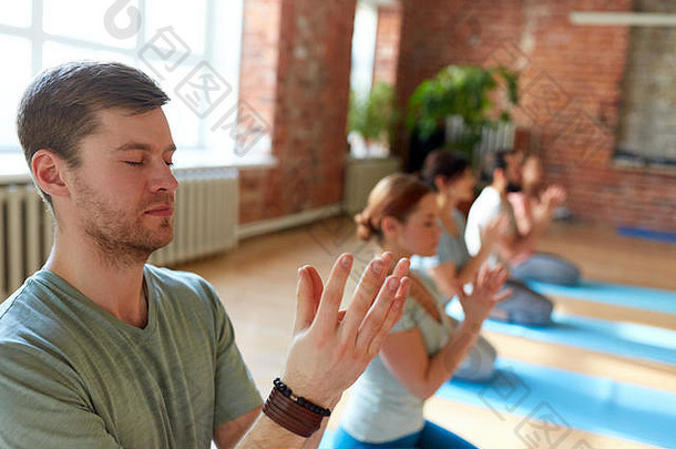 男人和一群人在瑜伽工作室冥想