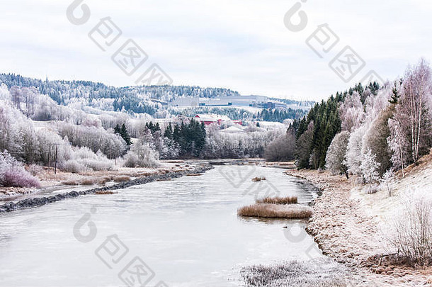 在挪威阿克苏县的一个自治市斯凯德斯莫，一条冬天下雪的河流穿过一个挪威村庄。