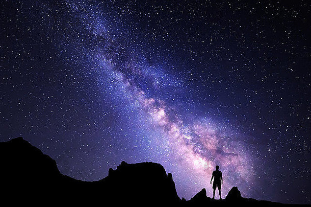 景观乳白色的晚上天空星星轮廓站快乐男人。山