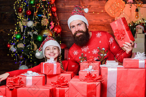 圣诞节最美好的<strong>童年</strong>回忆。父亲在圣诞树旁留着胡子的男人和女儿。花时间和家人在一起。爸爸和孩子打开圣诞礼物。这些都是圣诞老人送的。节日快乐。