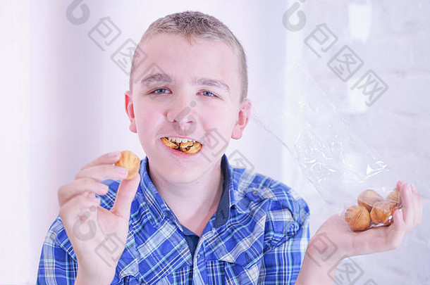 可爱的饥饿少年，在白色房间背景上独自拿着新鲜的小烤糖果