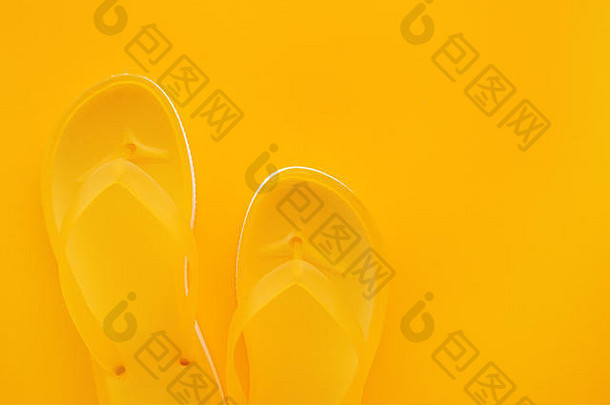黄色触发器对的俯视图，在相同的颜色背景上，具有空间。海滩凉鞋或拖鞋，简约温暖的夏季色调组合。