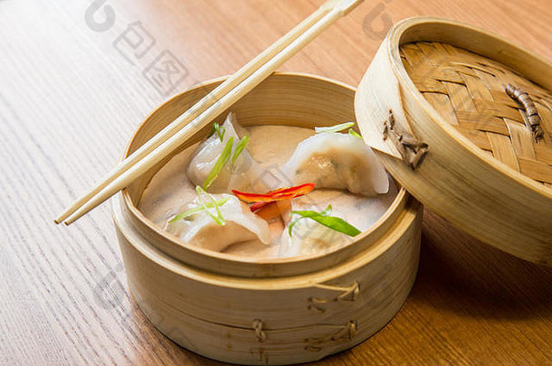 亚洲餐厅木桌上竹蒸笼里的虾仁点心