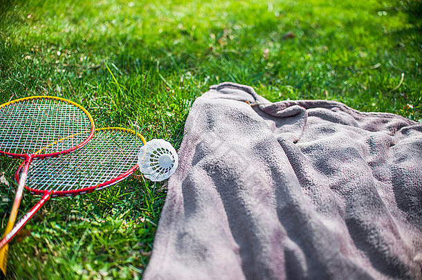 羽毛球羽毛球球拍蓝色的野餐毯子草场
