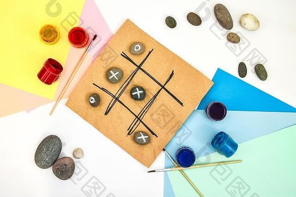 tic-tac-toe游戏的俯视图，石头上标记着零和十字架。儿童艺术项目，儿童手艺。DIY概念。一步一步地。