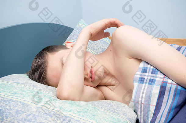 年轻的高加索人十几岁的男孩睡着了床上