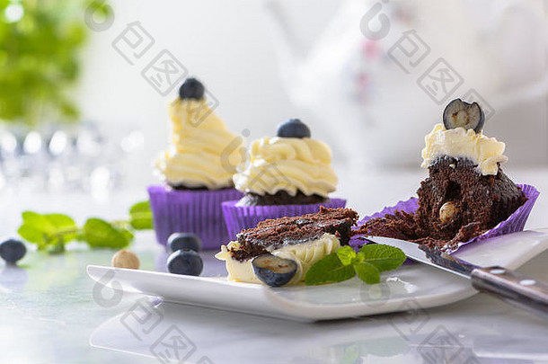 减少蛋糕白色板蓝莓榛子紫色的包装白色大理石表格前