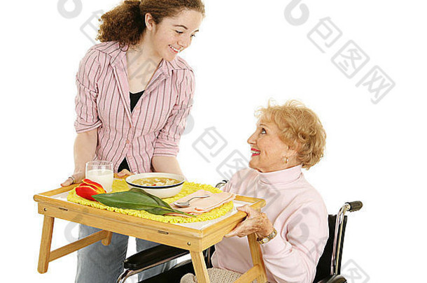 一名青少年志愿者为一名被隔离在白色街道上的残疾老年妇女提供汤